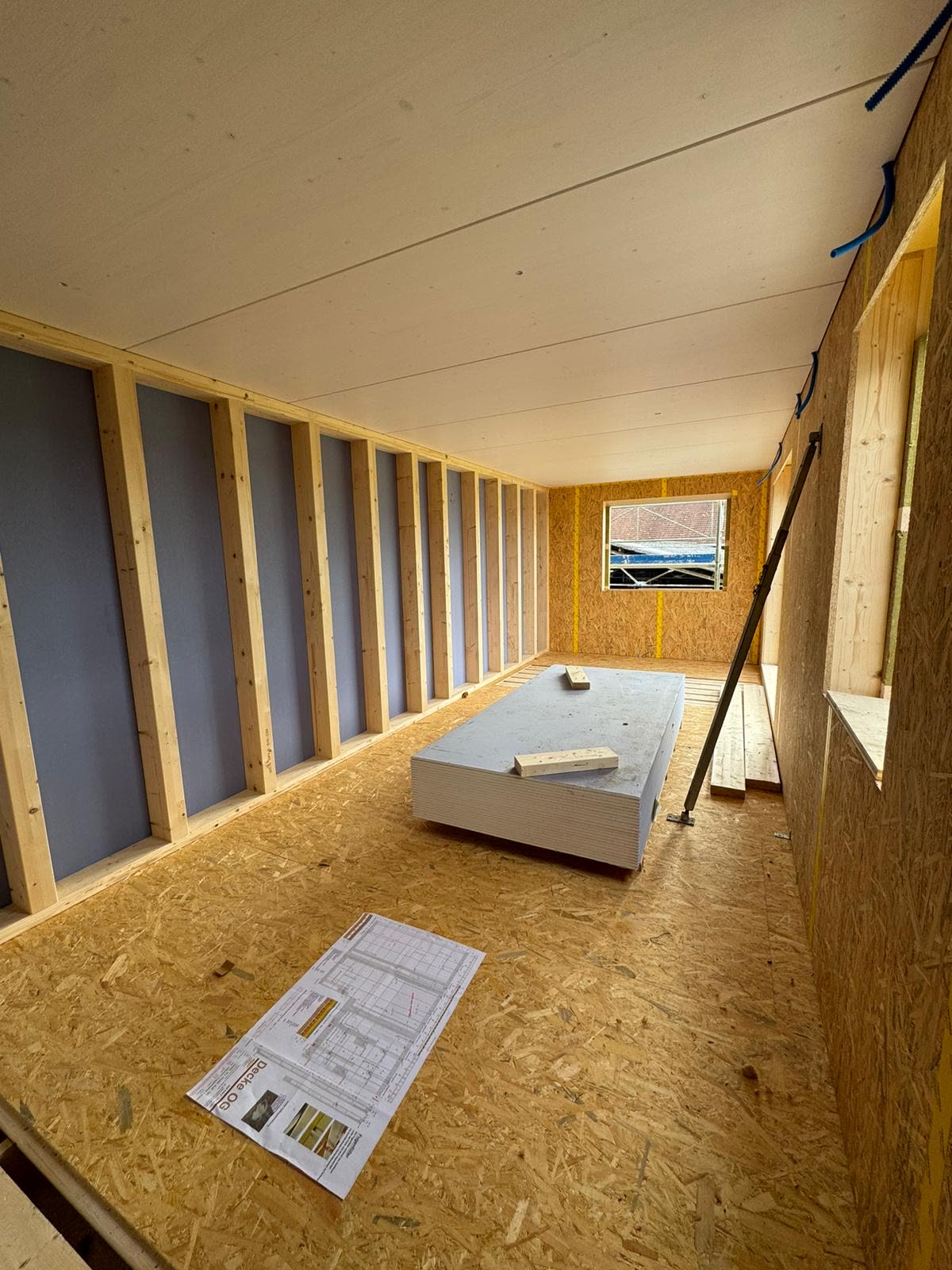 Holzbau-Innenraum (OSB-Boden, Fensterreihe) im Chrumbitzi-Neubau, Plan auf Boden