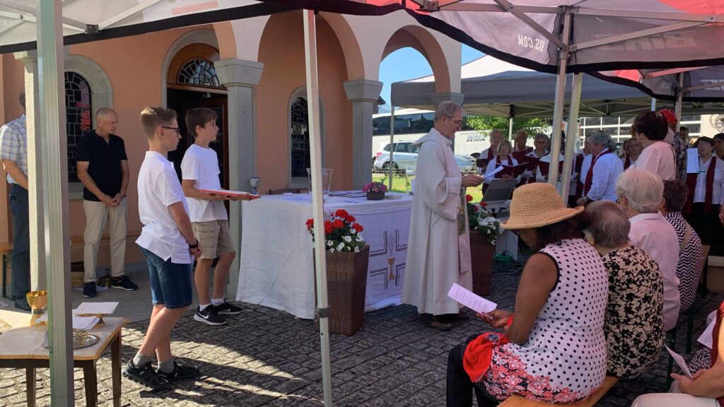Gottesdienst vor Kapelle mit Arkaden, Ministranten, Pfarrer, Besucher