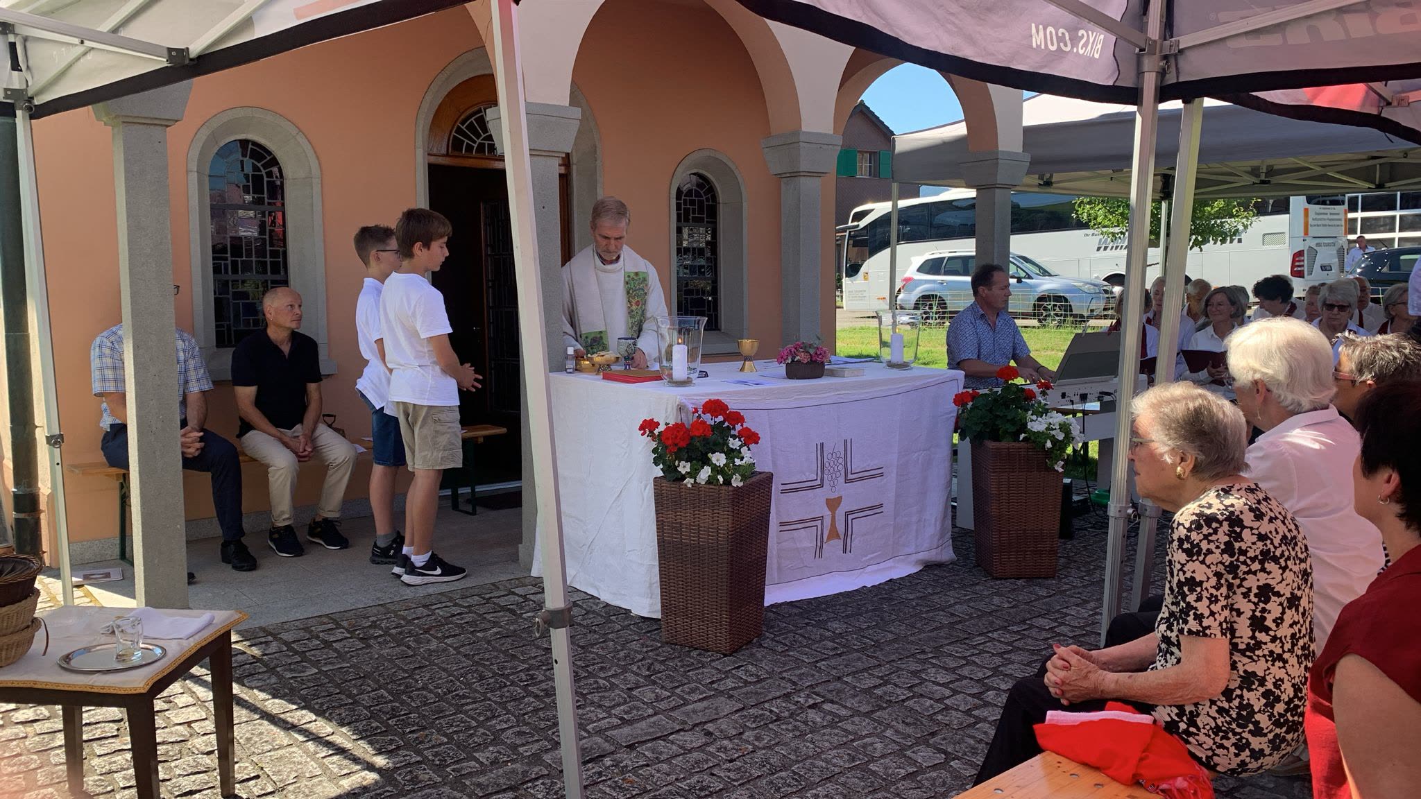 Altar vor Kapelle, Ministranten, Besucherinnen im Vordergrund