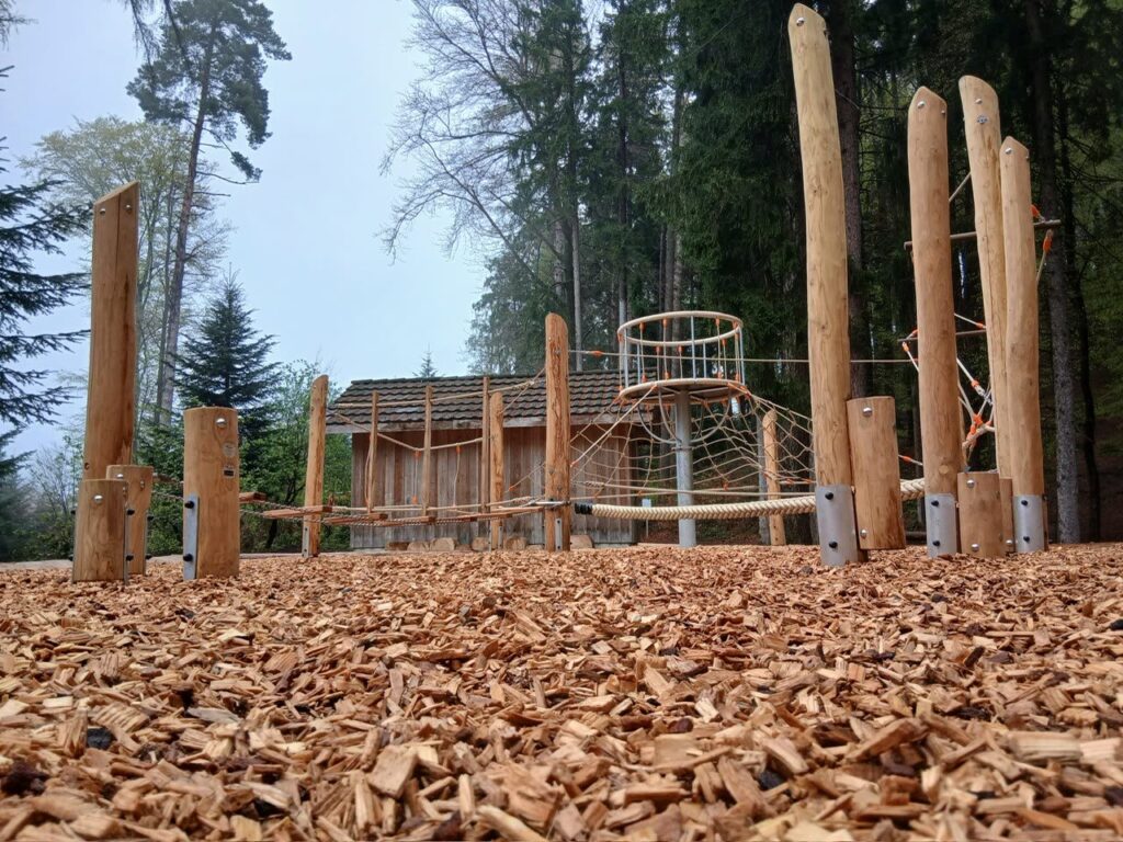 neuer Waldspielplatz mit Robinienstämmen, Kletternetzturm und Holzschnitzelboden, Waldhütte